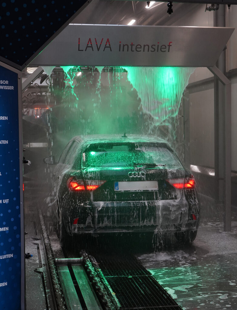 Een auto wordt grondig gereinigd door een automatische wasstraat met de "Lava intensief" wascyclus.